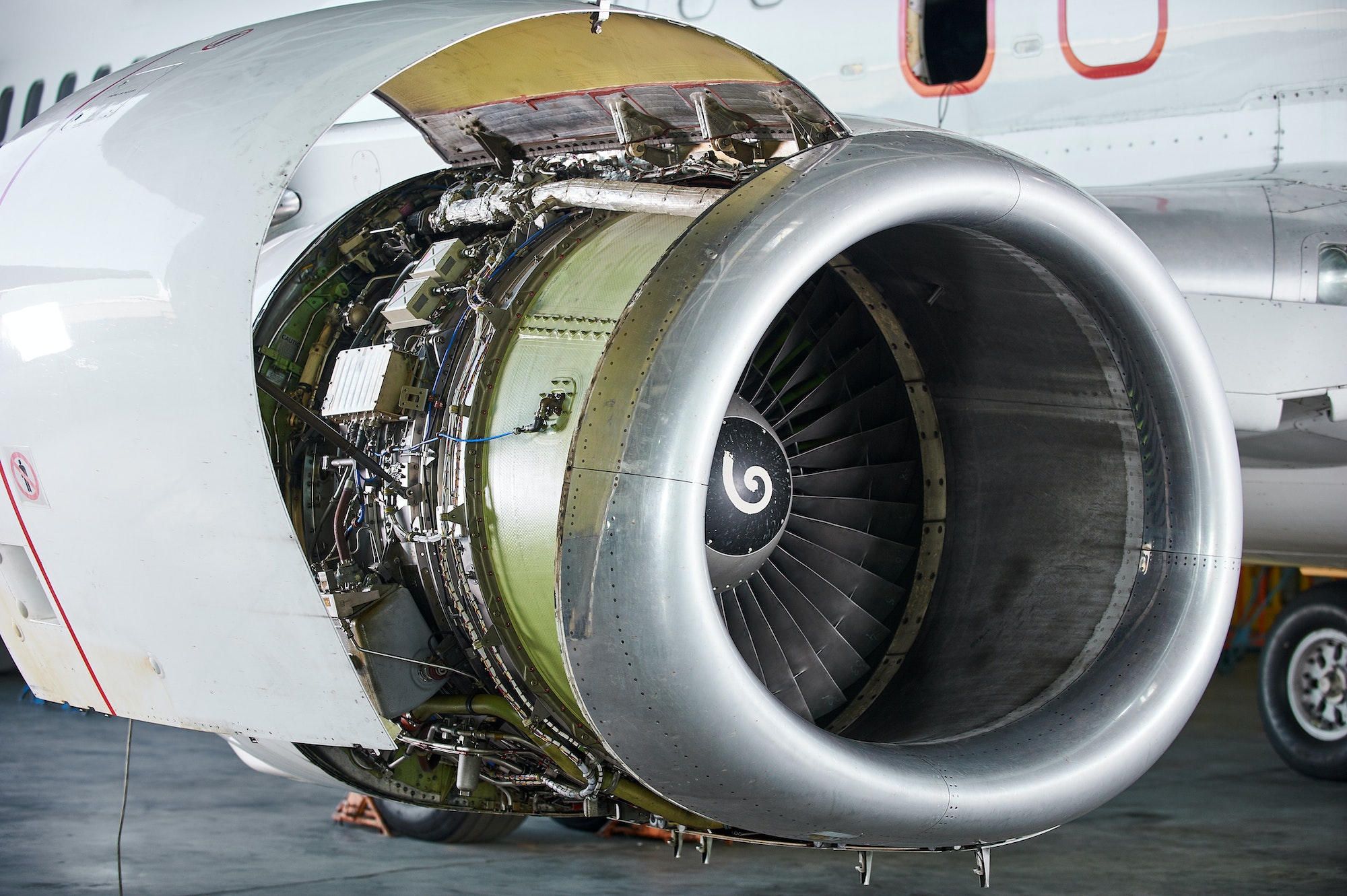 aircraft engine servicing - opened panels of a large engine of parked aircraft.